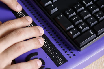 hands reading refreshable braille display